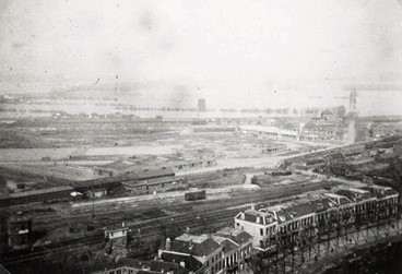 <p>Met de aanleg van de Noorderhaven, Gasfabriekhaven/Spoorweghaven en de groei van de industrie aan de overzijde van het spoor, nam het wegverkeer over de spoorwegovergang bij de Burg. Dijckmeesterweg en Coehoornsingel sterk toe. De doorgang naar het achtergelegen industrieterrein en de Marsweiden was echter vaak gesloten, vanwege regelmatig passerende treinen van en naar het rangeerterrein. In 1891 was vastgesteld dat op een doordeweekse dag de spoorbomen tussen 07.00 en 19.00 uur maar liefst 7,5 uur gesloten waren. Een voetgangersbrug (op deze foto uit 1939 te zien) kon de bezwaren maar voor een klein deel weghalen. (Vee)handelaren en industriëlen deden een dringend verzoek aan de Staatsspoorwegen om ter plaatse een tunnel aan te leggen. Praktische en economische bezwaren leidden ertoe dat de discussie voortduurde en dat de tunnel er uiteindelijk nooit is gekomen (RAZ beeldbank).</p>
